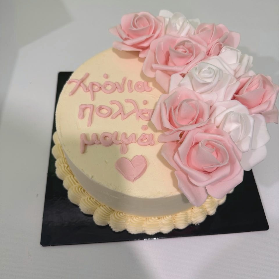 Cream celebration cake decorated with pink and white roses